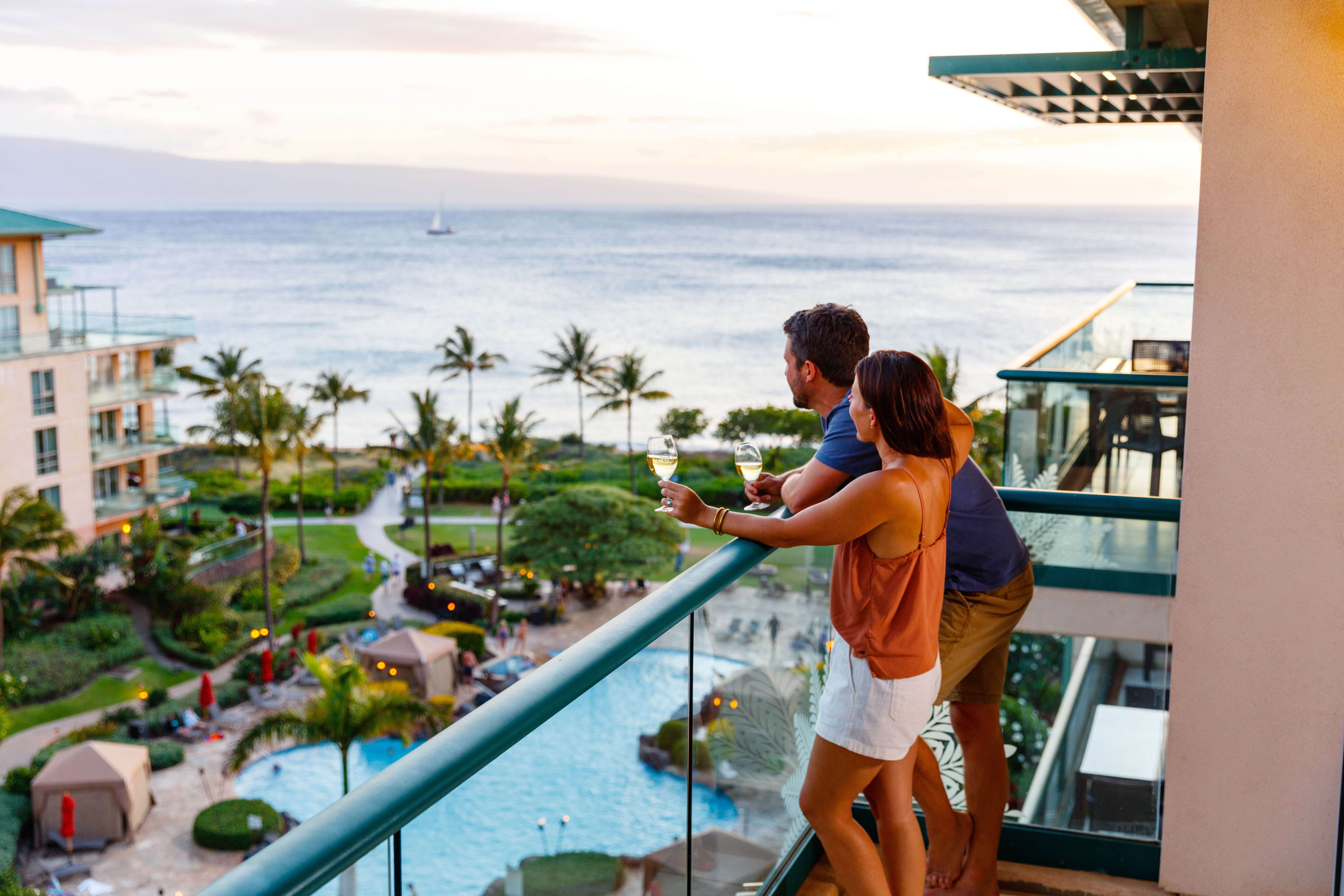 Couple enjoying the sunset view from the balcony at OUTRIGGER Honua Kai Resort & Spa